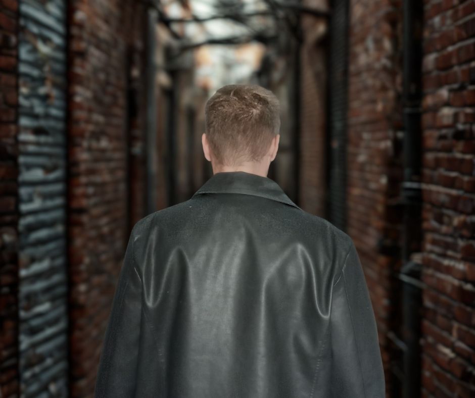 billy coull walking alone through city backstreet